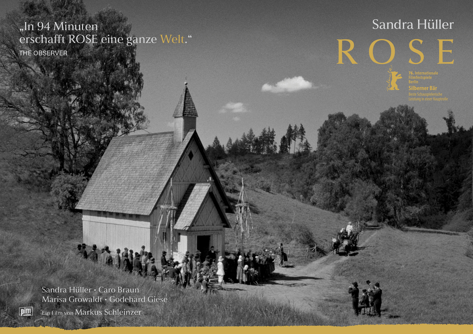 Filmszene aus Rose mit einer Musikgruppe und Menschenmenge vor einer Kapelle